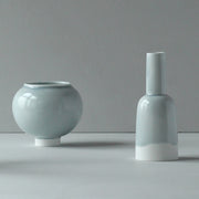 Small round pale blue round bowl with a  kiln shaped pale blue bottle with a white bottom 