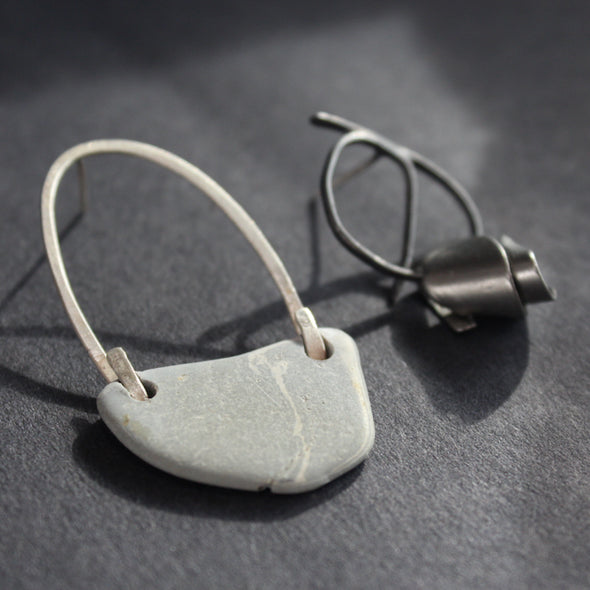 a pair of mis-matched earrings by Lizzie Weir of Anatole Design, made from found materials.