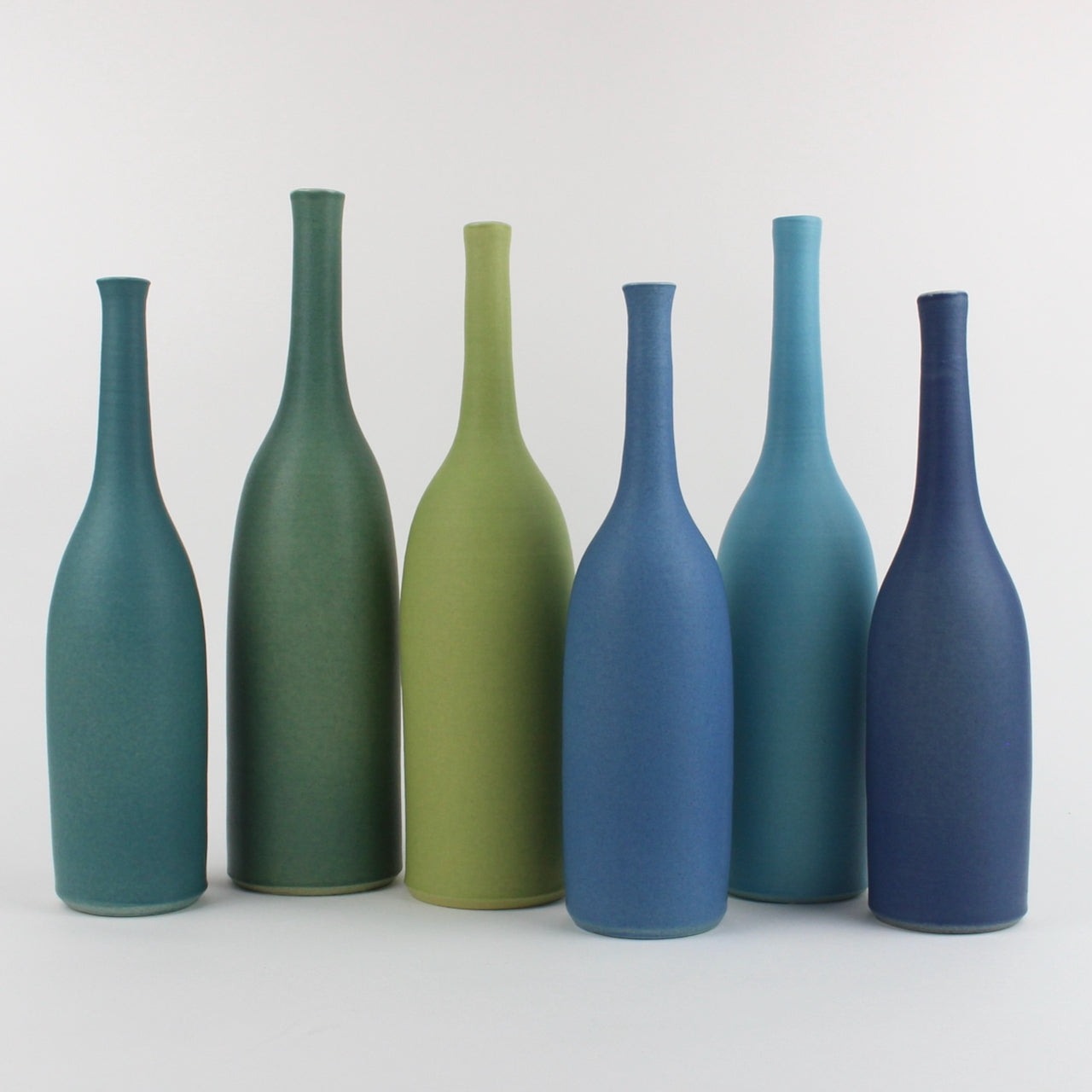 Lucy Burley ceramic bottle collection in shades of blue from petrol  blue to turquoise