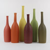 six ceramic bottles by Lucy Burley ceramicist in shades of orange, green and coral