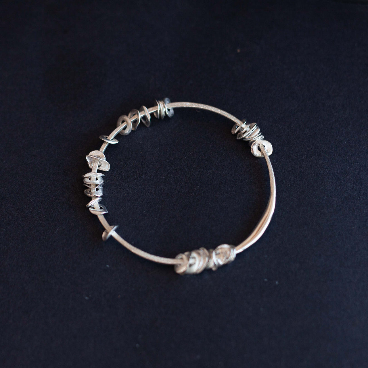 Silver sea siren bangle with silver pieces by Claire Stockings-Baker