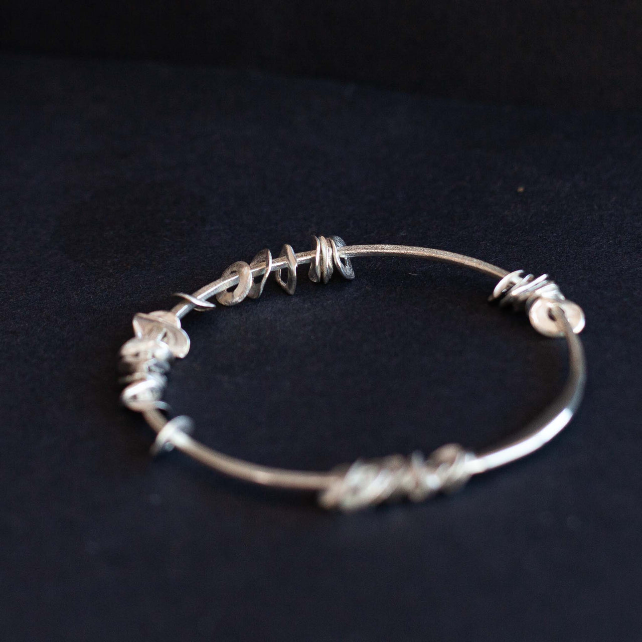 Silver sea siren bangle with silver pieces by Claire Stockings-Baker
