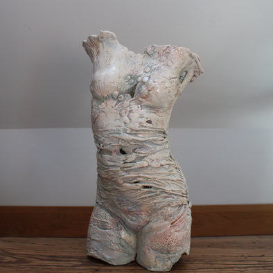 textured ceramic torso made by Pauline Lee standing on a wooden table 