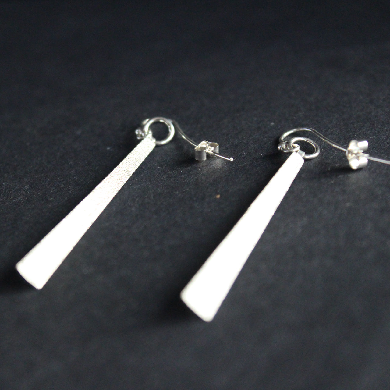 a pair of long silver earrings  by UK jeweller beverly bartlett.