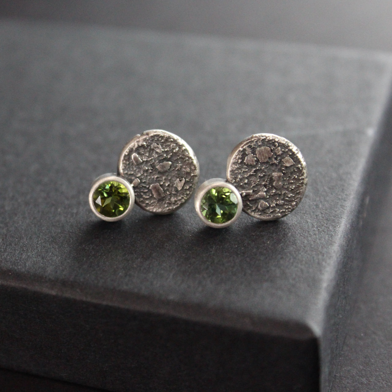 Carin Lindberg - Green tourmaline stud earrings in textured sterling silver displayed on raised box