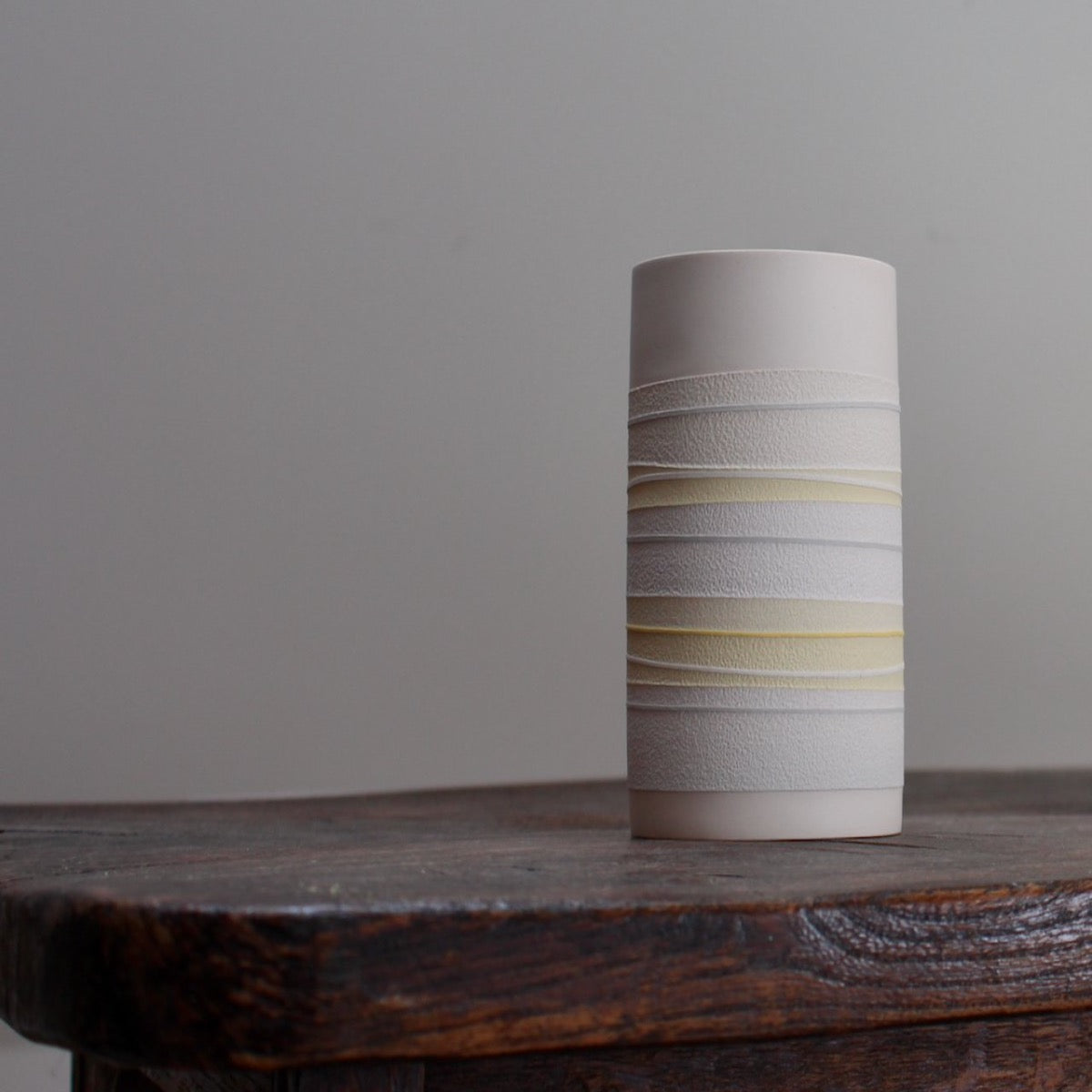 white ceramic vase with pale yellow stripes