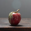 red ceramic apple with  a gold stalk by  Remon Jephcott