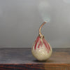 cream and pink ceramic pear with glaze details and a gold stalk by Cornwall ceramicist Remon Jephcott