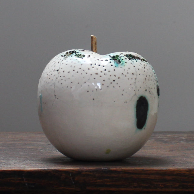 large ceramic white apple with a gold stalk by Remon Jephcott
