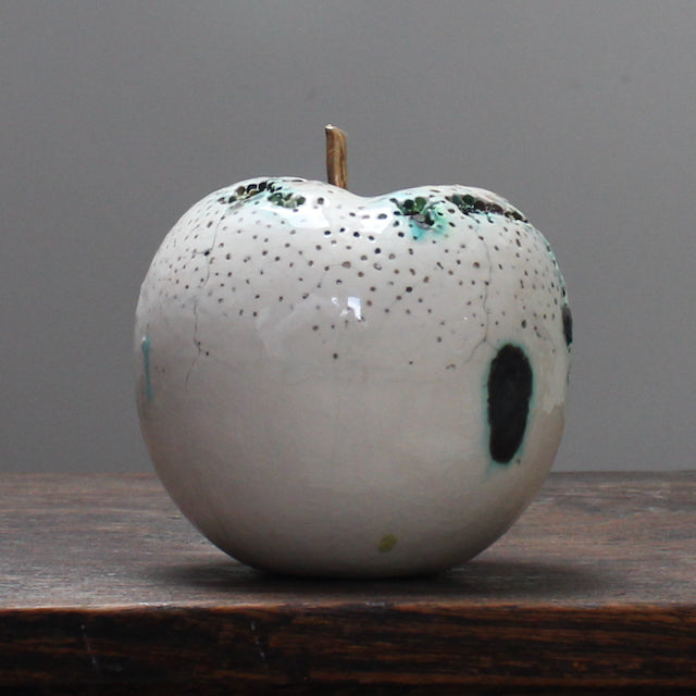 large ceramic white apple with a gold stalk by Remon Jephcott