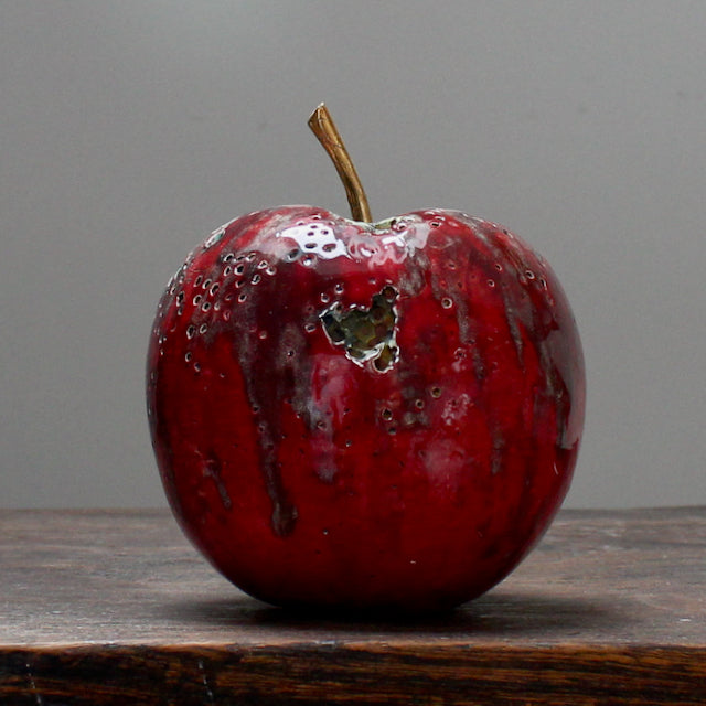 large ceramic white apple with a gold stalk and glaze details to mimic decay by Remon Jephcott
