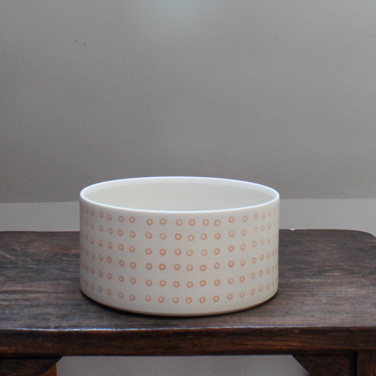 a porcelain dish decorated with small orange circles 