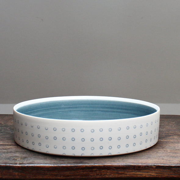 porcelain serving dish decorated with with blue dots and a blue interior 