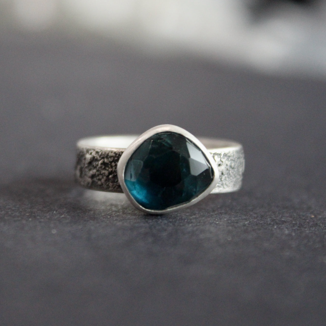 Blue tourmaline stone set in a textured silver ring