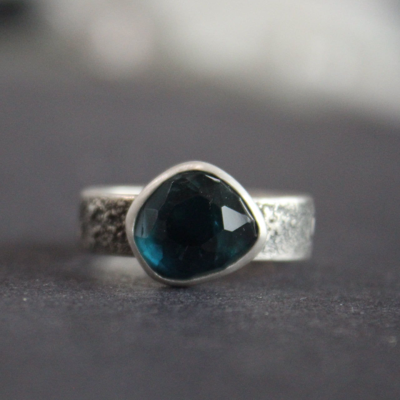 Blue tourmaline stone set in a textured silver ring 