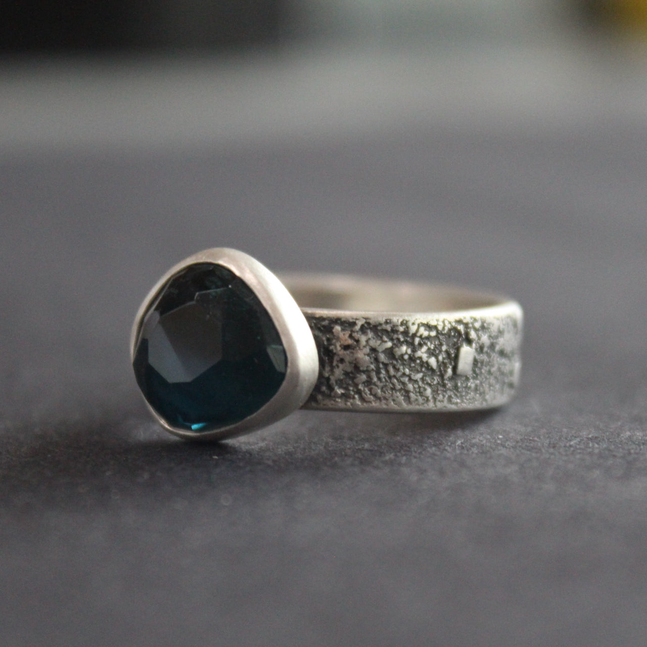 Blue tourmaline stone set in a textured silver ring 