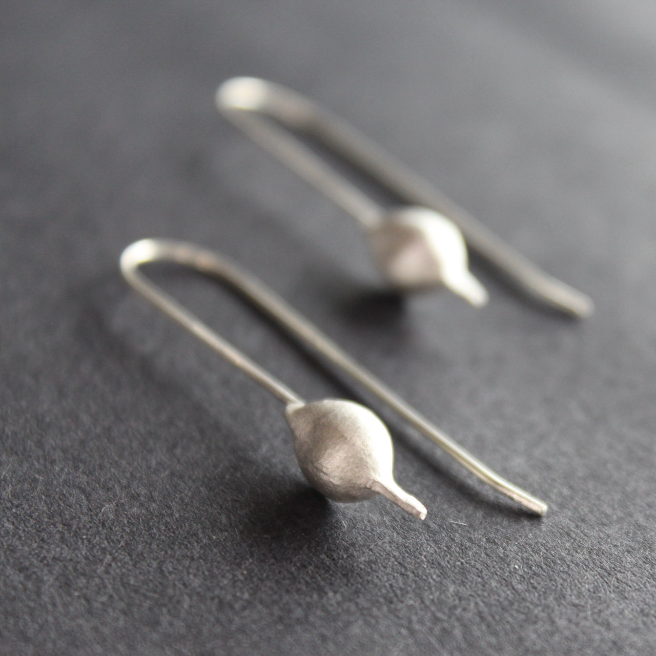 Silver drop earrings shaped like seedpods