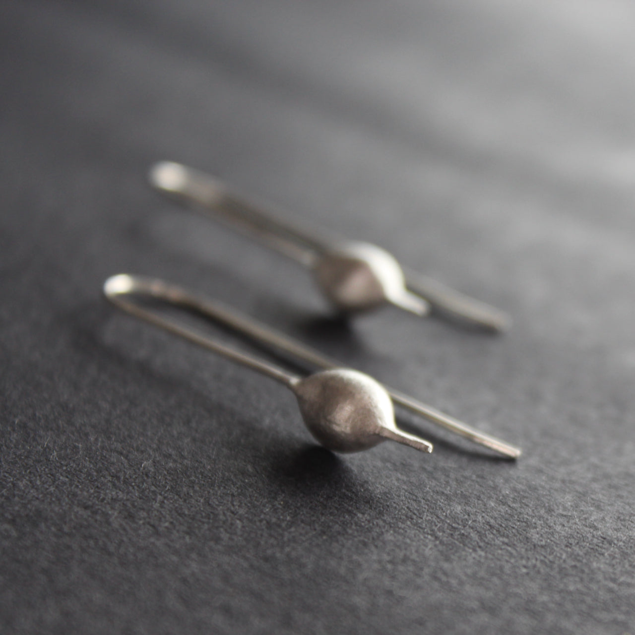 Silver drop earrings shaped like seedpods