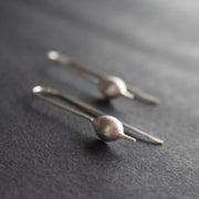 Silver drop earrings shaped like seedpods