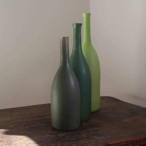 a trio of ceramic bottles in different shades of green and incremental sizes by Lucy Burley UK ceramicist 