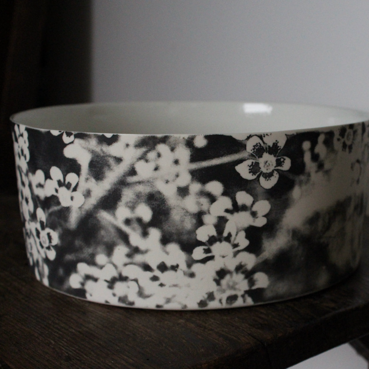 close up detail of a Heidi Harrington ceramic bowl with black and white pansy design on the exterior and a cream glazed interior