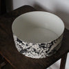 a Heidi Harrington ceramic bowl with black and white pansy design on the exterior and a cream glazed interior.