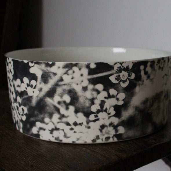 close up detail of a Heidi Harrington ceramic bowl with black and white pansy design on the exterior and a cream glazed interior 