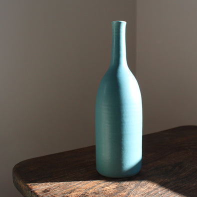 a dark turquoise coloured ceramics bottle by English ceramicist Lucy Burley.
