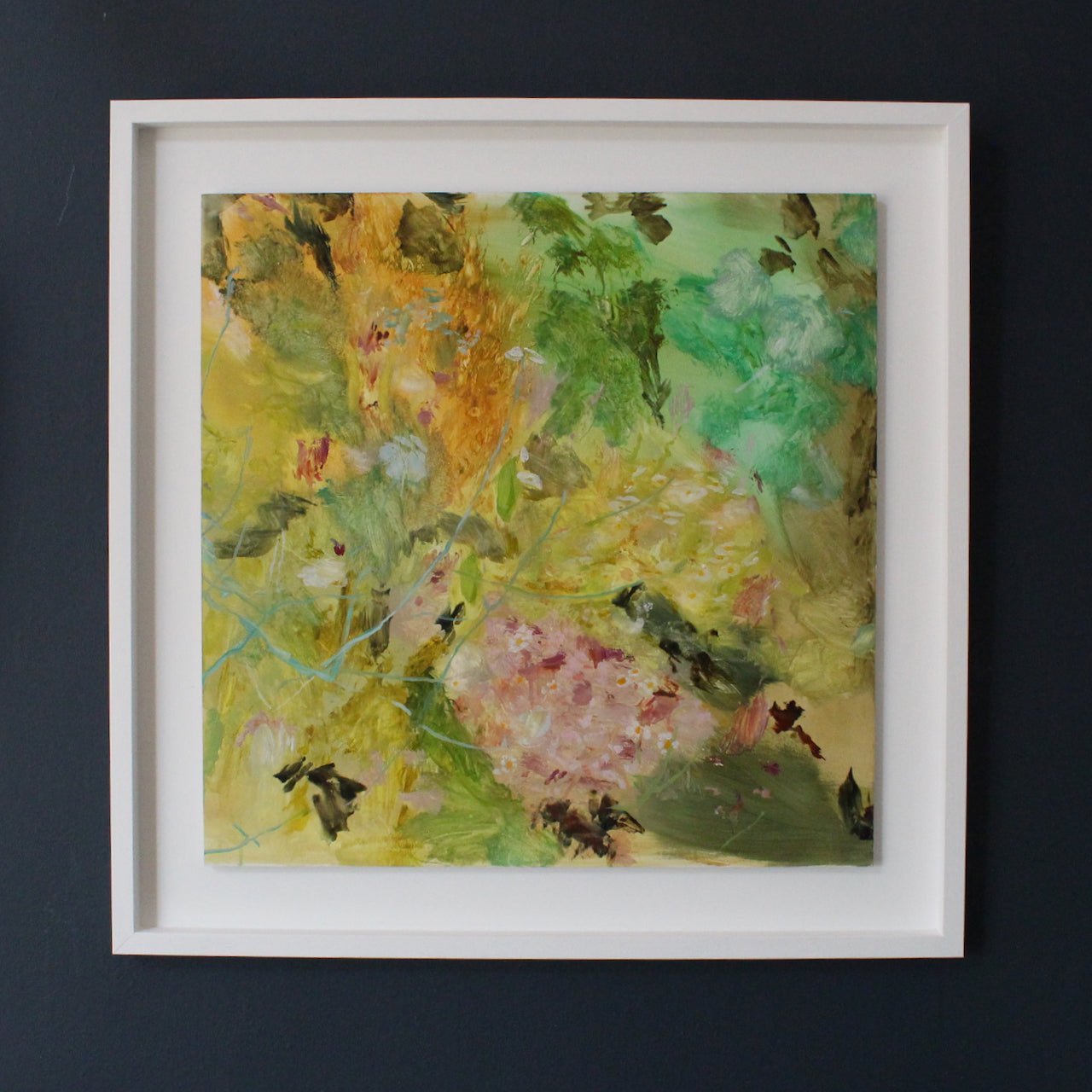 a framed abstract painting in yellow, greens and pink by artist Katy Brown of a garden of flowers it is called Amongst the Starflowers.