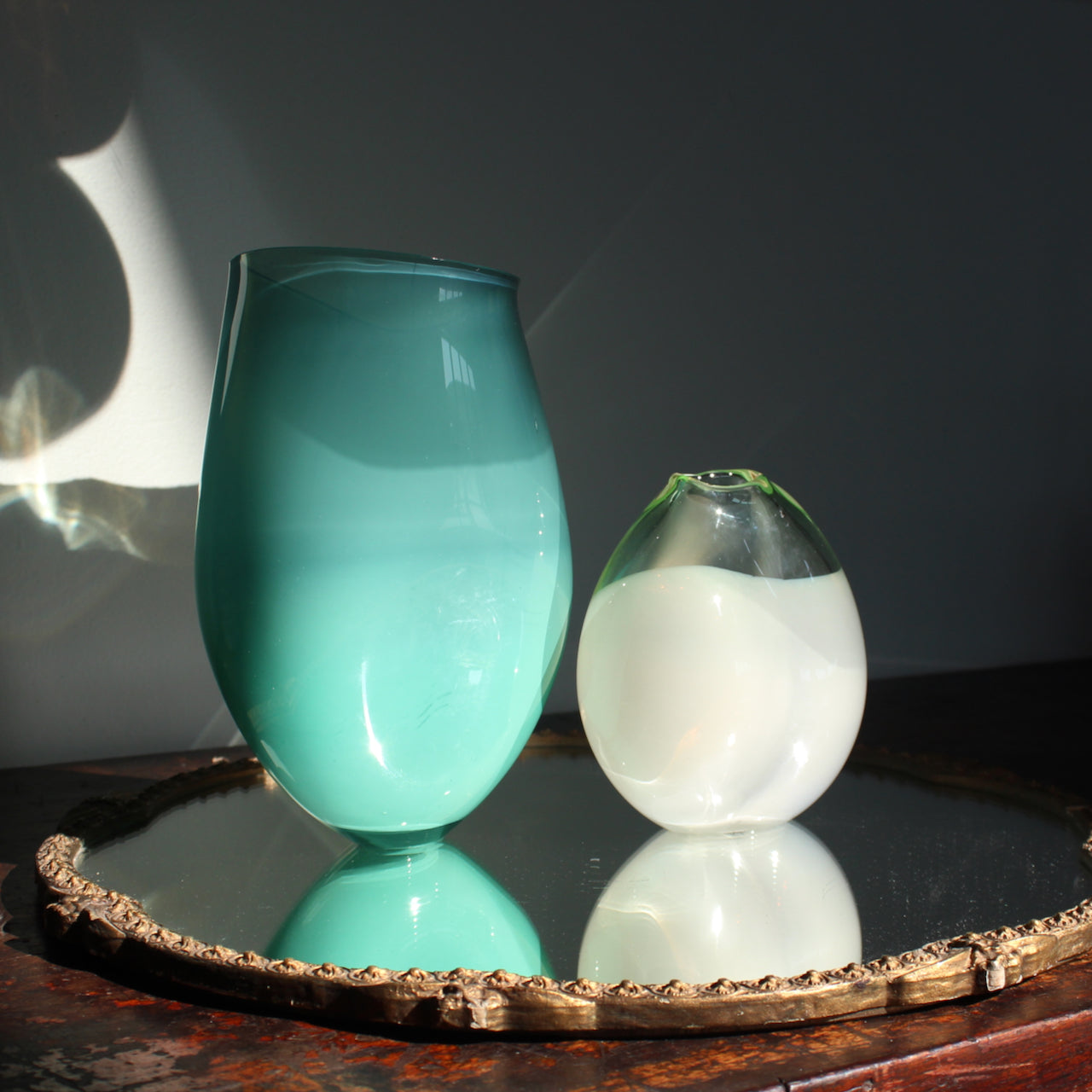 two glass vessels by glass artist Michele Oberdieck's one is in turquoise and the other pale green