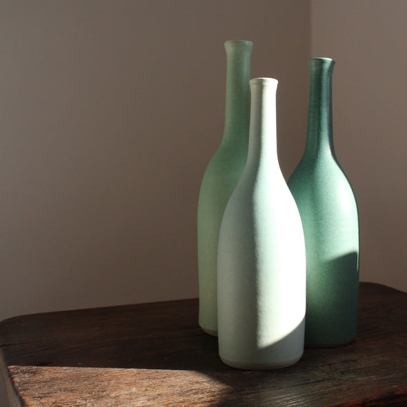 a set of three ceramic bottles in different shades of turquoise and incremental sizes by Lucy Burley UK ceramicist. 